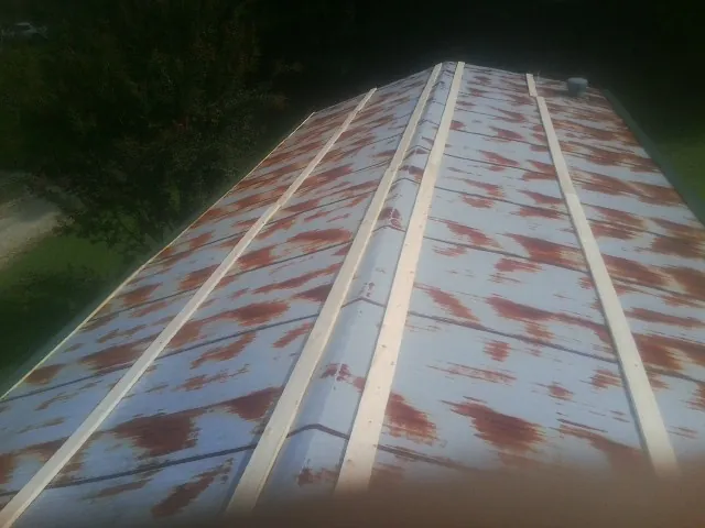 Rusted metal roof panels with new wood purlins before replacement — Storm Damage Roof Repair in Waelder by Roofing Brothers