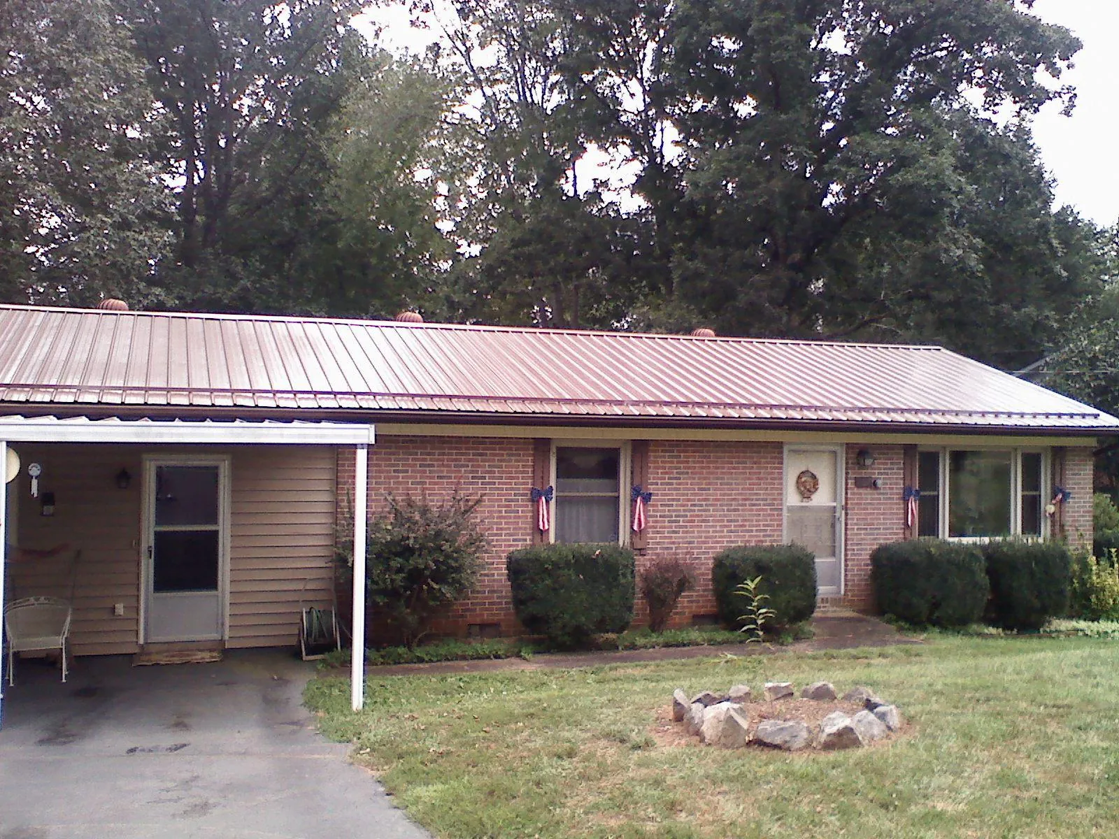 Bronze metal roof and carport on a brick ranch home — Roof Repair work by our crew in Waelder