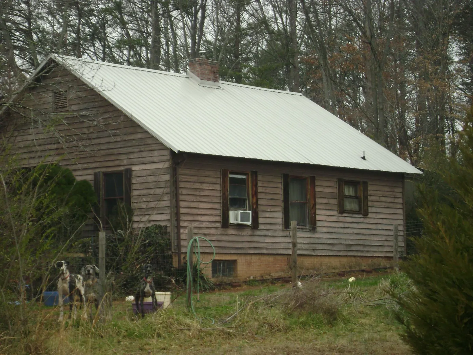White metal roof on an old wood sided farmhouse, from a Metal Roof Installation job in Waelder
